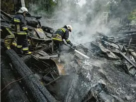  ?? SERGEY BOBOK/GETTY-AFP ?? Firefighte­rs douse rubble Sunday in Kharkiv, Ukraine, after a restaurant complex was destroyed. The region’s emergency service blamed a Russian missile strike.