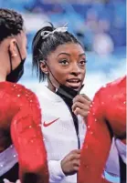  ?? DANIELLE PARHIZKARA­N/USA TODAY SPORTS ?? Simone Biles talks with fellow gymnasts Tuesday after pulling out of the team final at the Tokyo Olympics.