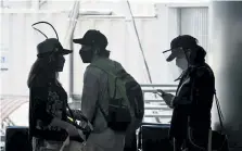  ?? Helen H. Richardson, Denver Post file photo ?? Travelers wear protective masks as they travel through Denver Internatio­nal Airport on July 7.
