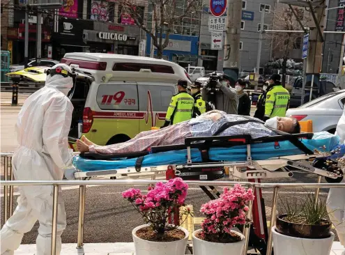  ?? FOTO: DPA/PA ?? Infektions­herd Südkorea: Sanitäter in Daegu transporti­eren eine Covid-19-patientin. In der Stadt gab es im März einen Massenausb­ruch.