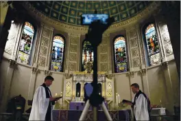  ?? EMILY LESHNER — THE ASSOCIATED PRESS ?? On March 29, the Rev. Steven Paulikas, right, and curate Spencer Cantrell deliver an evening prayer service over Facebook Live in the Brooklyn borough of New York.