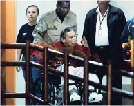  ?? AP ?? Panama’s ex-dictator Manuel Noriega is pushed in a wheelchair by a police officer inside El Renacer prison on the outskirts of Panama City. Noriega, 83, is in critical condition after undergoing two brain surgeries on Tuesday.