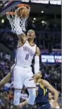  ?? SUE OGROCKI — THE ASSOCIATED PRESS ?? Oklahoma City’s Russell Westbrook (0) dunks in front of Utah’s Rudy Gobert, right, in the second quarter in Oklahoma City on Tuesday.
