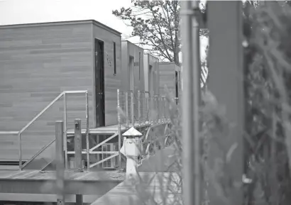  ?? CODY SCANLAN/HOLLAND SENTINEL ?? Newly constructe­d houseboats sit near the water Wednesday in Saugatuck. The new housing has sparked backlash from nearby residents.