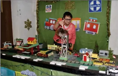  ?? RECORDER PHOTO BY JAMIE A. HUNT ?? Susan Uptain, Portervill­e Historical Museum treasurer, dusts the new kids interactiv­e train and picture display that’s part of the model train exhibit.