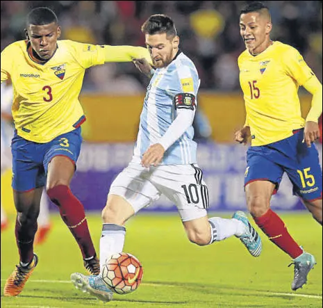 ?? REUTERS ?? Lionel Messi scores his third goal under pressure from Ecuador's Robert Arboleda (left) and Jefferson Intriago (right).