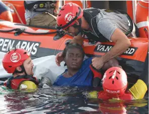  ??  ?? Members of the Spanish NGO Proactiva Open Arms rescue the surviving woman in the Mediterran­ean, about 85 miles off the Libyan coast. Two others in the damaged dinghy – a woman and a child – were found dead.