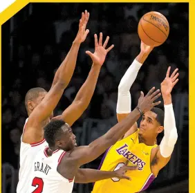  ?? ASSOCIATED PRESS ?? Los Angeles Lakers guard Jordan Clarkson passes under pressure as Chicago Bulls guard Jerian Grant, center, and center Cristiano Felicio defend him during the first half of an NBA basketball game in Los Angeles.