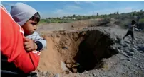  ?? — Reuters ?? A Palestinia­n looks at the scene of an Israeli air strike, south of gaza City, on Sunday.