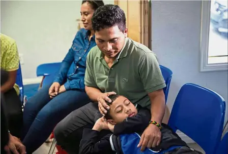  ?? — AFP ?? Brief respite: An immigrant from El Salvador and his 10-year-old son resting after being released from detention through the ‘catch and release’ immigratio­n policy at a Catholic Charities relief centre in McAllen, Texas. The man said he was separated...