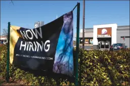  ?? JUSTIN SULLIVAN/GETTY IMAGES ?? A “now hiring” sign in posted in front of a Taco Bell restaurant on Feb. 5 in Novato. Employers continued to add jobs through March, with the unemployme­nt rate falling to 6%.