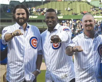  ?? | DAVID BANKS/ GETTY IMAGES ?? Former Cubs Jason Hammel ( from left), Jorge Soler and TravisWood, all nowwith the Kansas City Royals, show off the 2016 World Series rings theywere given in a pregame ceremony Monday atWrigley Field.