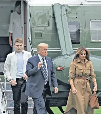  ??  ?? Donald Trump, his son Barron, 14, and wife Melania disembark Marine One. The president is trailing Joe Biden in the polls