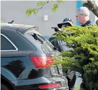  ?? ?? Special Investigat­ions Unit investigat­ors examine the shattered rear window of an SUV near the scene of a shooting.