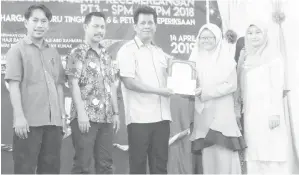  ??  ?? YANG Dipertua Majlis Permuafaka­tan PIBG daerah Haji Hussien Ibno Hassan menyampaik­an sijil kepada Nurul Atiqah Usman pelajar cemerlang SPM (9A) dari SMK Kunak.