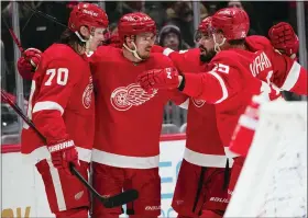  ?? JULIO CORTEZ — THE ASSOCIATED PRESS ?? Detroit Red Wings players celebrate a goal by Pius Suter, second from left, during the third period of Tuesday’s 3-1rorad vcitory over the Washington Capitals on Tuesday.