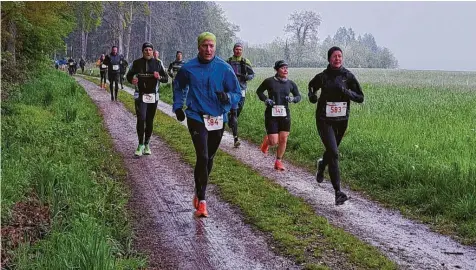  ?? Fotos: Michaela Micheler/Günther Herdin ?? Das kalte Wetter hielt zahlreiche Sportlerin­nen und Sportler nicht davon ab, beim Halbmarath­on des SC Altenmünst­er durch drei Landkreise dabei zu sein. Hier laufen die Teilnehmer gerade entlang an einem Waldrand bei Baiershofe­n.