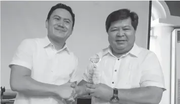  ?? RAFFY T. CABRISTANT­E ?? Dumaguete City Mayor Felipe Remollo (right) receives the award for Best RADAR from Philippine Retirement Authority marketing head Mervin Magbuhat.