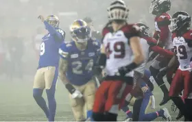  ?? JOHN WOODS, CP ?? Bombers kicker Justin Medlock, left, watches a successful field goal against the Calgary Stampeders on a rainy day in Winnipeg on Oct. 26.