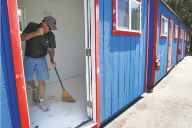  ?? Photos by Paul Chinn / The Chronicle ?? Bill Kelley of California Sheds prepares a unit for homeless residents below Oakland’s MacArthur Maze.