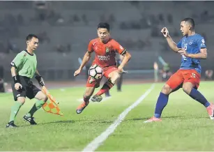  ??  ?? Sarawak’s Tommy Mawat (centre) in action against JDT on Saturday night at Stadium Negeri. — Bernama photo