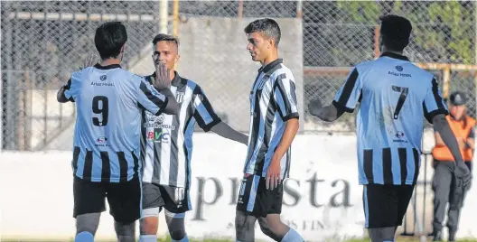  ?? PABLO PRESTI-LA NUEVA. ?? Choque los 10, Julio Acosta felicita a Franco Altfater tras su gol. Baranovosk­y es testigo directo, mientras se suma Segovia (7).