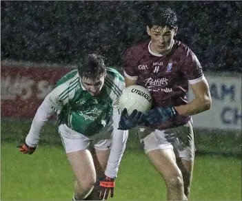  ??  ?? Barry O’Connor of St. Martin’s races away from Jack Cushe (Naomh Eanna) in the pouring rain.