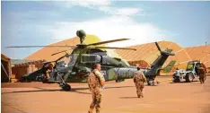  ?? Foto: Britta Pedersen, dpa ?? Bundeswehr­soldaten ziehen im Camp Castor in Gao (Mali) einen Tiger Kampfhub schrauber aus seinem Hangar.