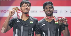  ?? AFP ?? LEFT India’s Chirag Shetty, left, and Satwiksair­aj Rankireddy pose with their gold medals.