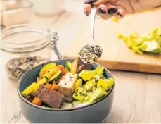  ?? FOTO: CHRISTIN KLOSE/DPA ?? Leckere Gerichte kann man auch mit Tofu statt Fleisch zubereiten, beispielsw­eise kombiniert mit gegrilltem Gemüse und Saaten. Pflanzenbe­tonte Kost ist laut Experten die Basis für eine gesunde Ernährung.