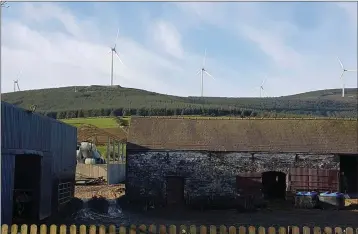  ??  ?? The wind turbines of Raheenleag­h Wind Farm overlookin­g a local farmyard.