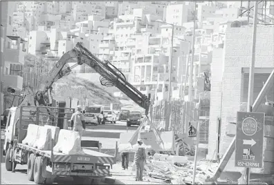  ?? (AFP) ?? Labourers work at a housing constructi­on site in the Israeli settlement of Har Homa in east Jerusalem on Feb 27. Israel’s constructi­on in east Jerusalem is a deliberate strategy to prevent the city from becoming capital of two states, an internal EU...