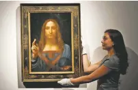  ?? KIRSTY WIGGLESWOR­TH/ASSOCIATED PRESS FILE PHOTO ?? An employee poses with Leonardo da Vinci’s display in 2017 at Christie’s auction rooms in London.