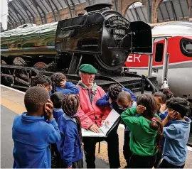  ?? Leon Neal/Getty Images ?? Sir Michael Morpurgo and his young fans cover their ears as the Flying Scotsman sounds its whistle at King’s Cross station