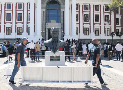  ?? Picture: Reuters ?? UNDER MADIBA’S NOSE. Parliament­ary workers carry scaffoldin­g outside parliament yesterday after it was announced that President Jacob Zuma’s State of the Nation address has been postponed.