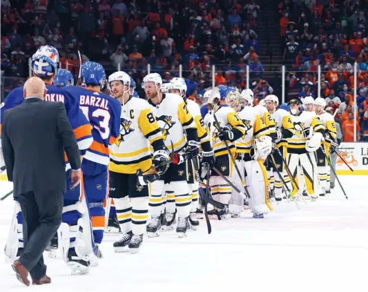  ?? PHOTO AFP ?? Sidney Crosby suivi par ses coéquipier­s ont félicité les joueurs des Islanders qui passent au deuxième tour des séries.