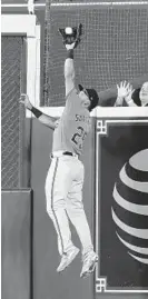  ?? BOB LEVEY/GETTY ?? The Orioles’ Anthony Santander leaps at the wall to take a home run away from Houston’s Yuli Gurriel on Saturday.