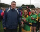  ??  ?? Captain Ciara O’Connor being presented with the trophy by Castlecome­r principal Seamus O’Connor on behalf of Leinster schools camogie.