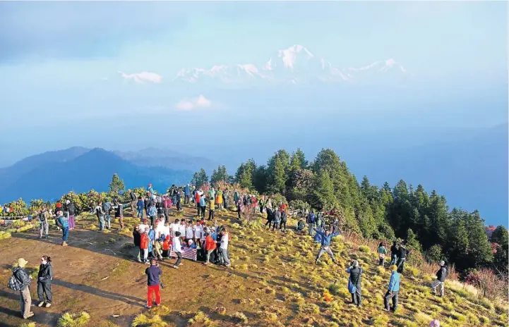  ?? Pictures: MATTHEW STERNE ?? DAWN ON ME: Hikers enjoy the famous sunrise view from Poon Hill, commonly referred to as “The best view in Asia”. The world’s seventh-tallest mountain, Dhaulagiri, can be seen in the background