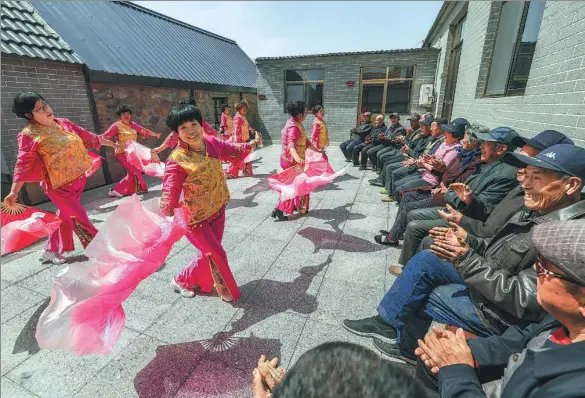  ?? LI XINJUN / XINHUA ?? Volunteers perform a folk dance to entertain the elderly on the premises of a canteen in Jiakuangma­jia village, Rongcheng city, Shandong province, on April 16. Rongcheng operates 363 canteens that offer free lunches to 12,000 rural people aged above 80.