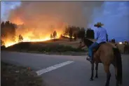  ?? (AP/Matthew Brown) ?? Rowdy Alexander watches Wednesday from atop his horse as a hillside burns on the Northern Cheyenne Indian Reservatio­n near Lame Deer, Mont.