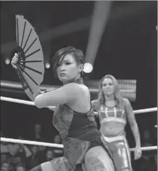  ??  ?? Xia Li strikes a pose with a Chinese fan before her match with Martinez.