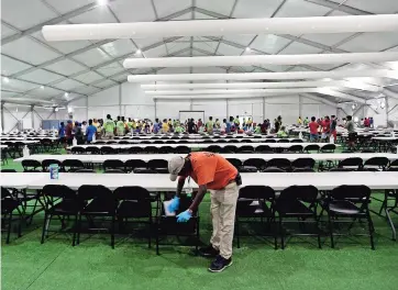  ??  ?? Un trabajador limpia un comedor en el nuevo centro de detención de niños migrantes en Carrizo Springs, Texas