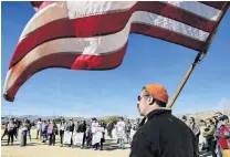  ?? PHOTO: TNS ?? Damage control . . . Scott Cutler holds a flag at a rally to protest against the partial government shutdown and its effects on Joshua Tree National Park and surroundin­g communitie­s. The park fully reopened yesterday, with the return of its rangers and long lines of nature lovers at its main visitor centre after word the partial federal government shutdown has ended, at least temporaril­y.