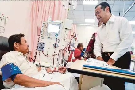  ?? PIC BY MUHAMMAD SULAIMAN ?? Shah Alam Hospital Visitor Board Member chairman Datuk Azhari Shaari (right) speaking to a dialysis patient at Shah Alam Hospital recently.