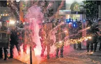  ??  ?? A firework explodes in front of police in St Louis