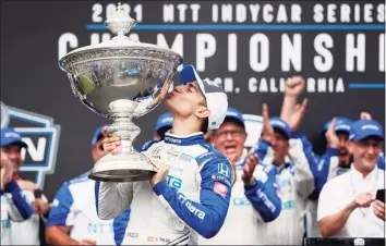  ?? Alex Gallardo / Associated Press ?? NTT IndyCar Series winner Alex Palou, center, celebrates with the trophy after taking fourth place in an IndyCar auto race at the Grand Prix of Long Beach on Sunday in Long Beach, Calif.