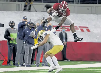  ?? AP ?? Alabama running back Najee Harris goes up and over Notre Dame cornerback Nick McCloud during the Crimson Tide’s Rose Bowl win over the Fighitng Irish yesterday.