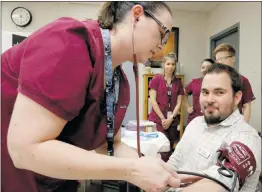  ??  ?? Nikolas Samuels/The Signal Certified medical assistant student Victoria Howard tests the blood pressure of high school diploma instructor Scott Davidson at Golden Oak Adult School last month.