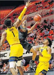  ?? [NATE BILLINGS/ THE OKLAHOMAN] ?? Oklahoma State's Avery Anderson III, center, tries to score between West Virginia's Derek Culver, left, and Miles McBride last week during the Cowboys' 55-41 loss.